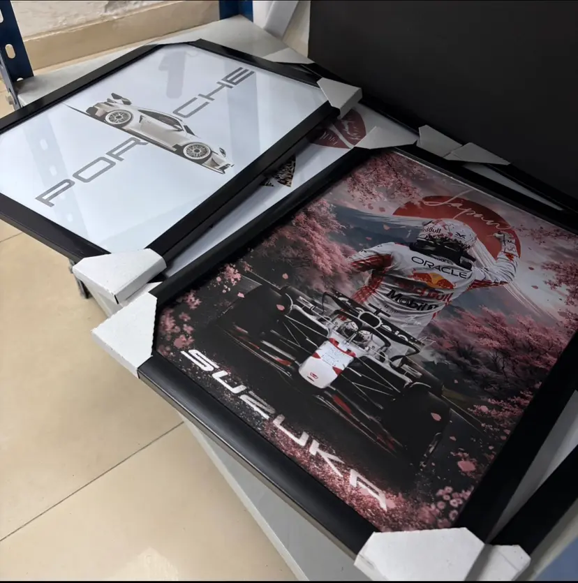 Framed Porsche and Formula One posters with corner protectors, packed for delivery